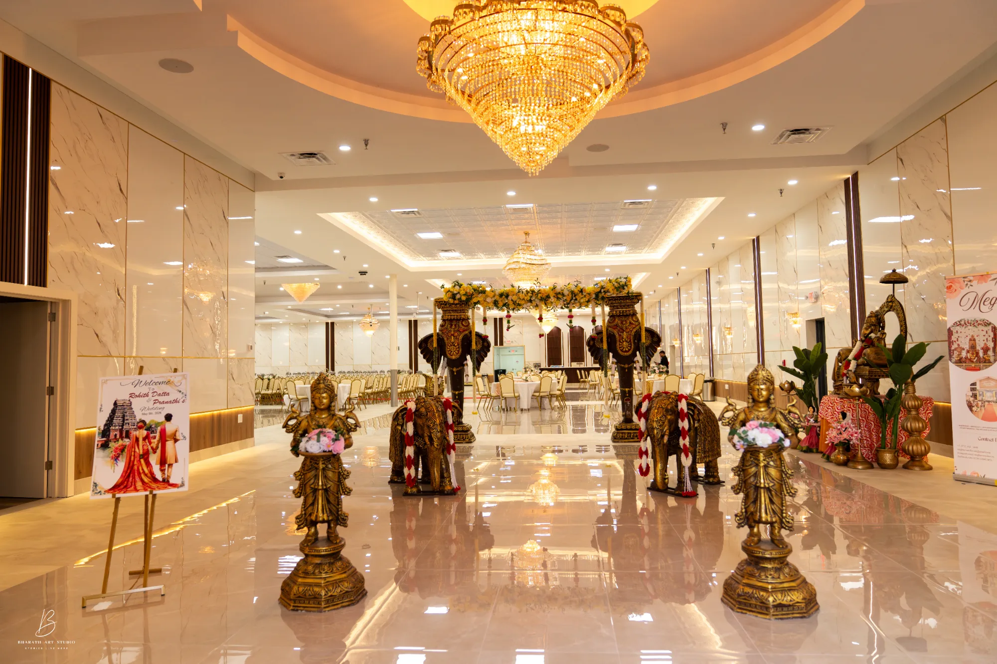 Grand entrance with gilded deity statues and garlanded elephants leading toward the mandap at Triveni Banquet near Dulles, Northern Virginia